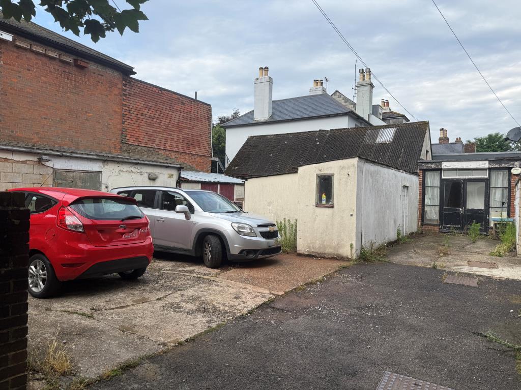 Lot: 22 - SUBSTANTIAL MIXED USE PERIOD PROPERTY WITH DEVELOPMENT POTENTIAL - View of parking arwa at rear with outbuildings